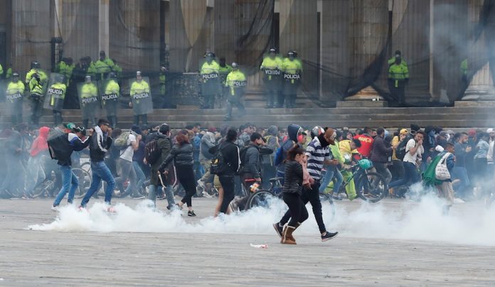 Miembros de las fuerzas del orden dispersan con gases a manifestantes, durante un cacerolazo este viernes en la Plaza Bolívar de Bogotá. | Foto: Efe/Mauricio Dueñas Castañeda