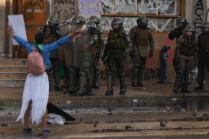 Una manifestante increpa a Carabineros en la céntrica Plaza Italia, rebautizada popularmente como 