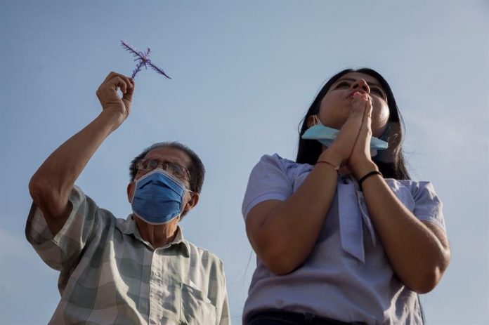 Personas observan el recorrido del Nazareno de San Pablo abordo del papamóvil que utilizó Juan Pablo II durante su visita a Venezuela en 1985, este Miércoles Santo en Caracas. | Foto: EFE/RAYNER PEÑA R.