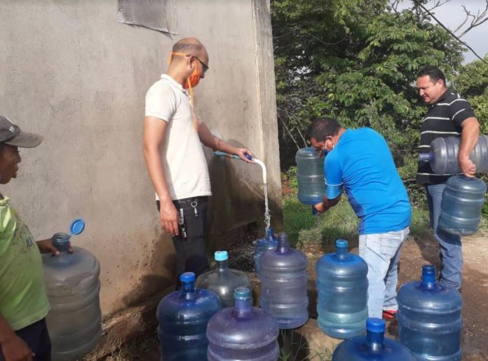 Los habitantes de Machiques, salieron de sus casas este lunes para recolectar el líquido en las tomas de agua de empresas privadas que facilitan el suministro de agua. Foto: Johandry Andrea Montiel.